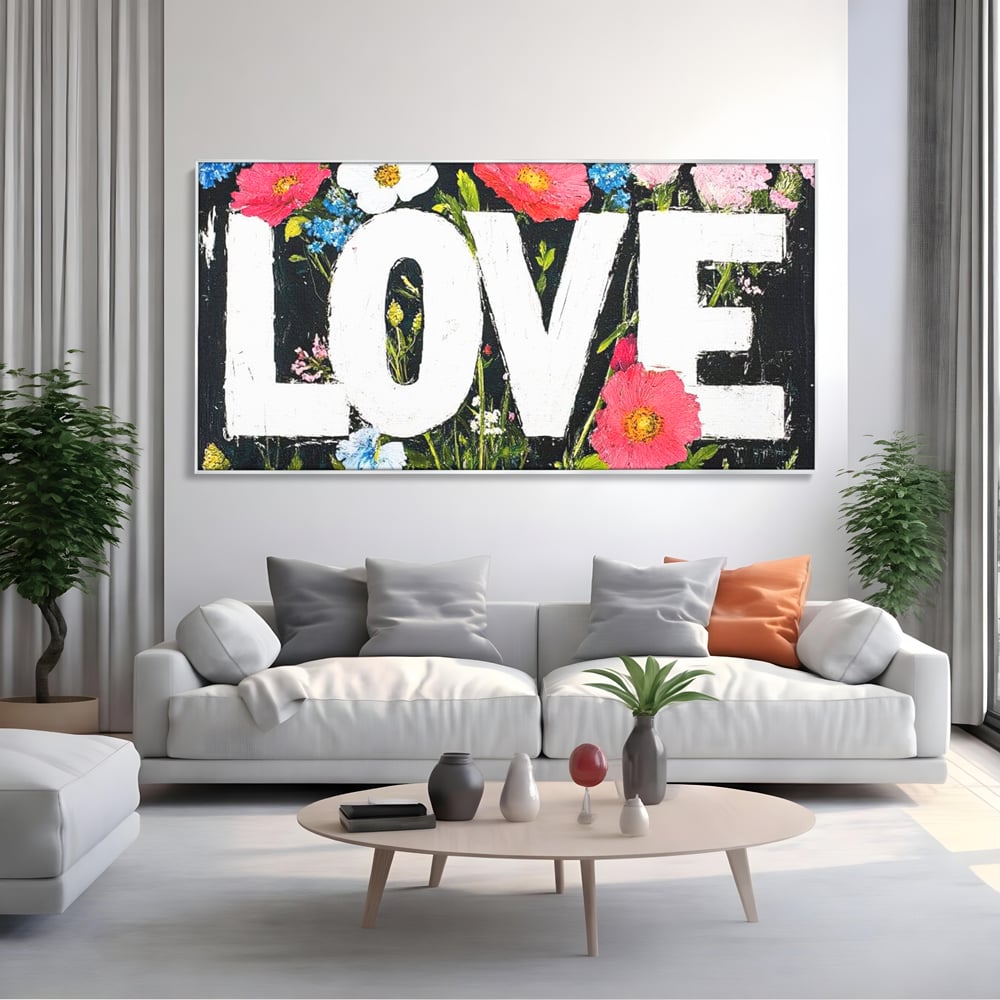Tablou canvas cu tablou canvas cu flori si cuvantul love, in rama de aluminiu argintiu, pe perete intr-un living